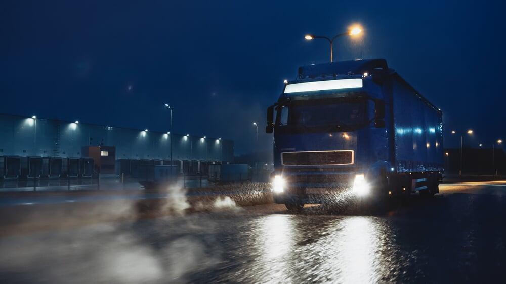 A truck driving on a road at night