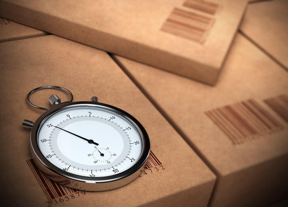 A stopwatch on top of a box that shows a barcode
